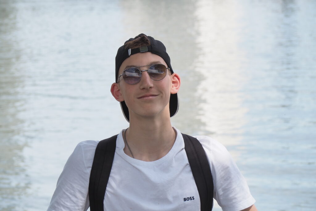 Mann mit Sonnenbrille und Cap am Fluss